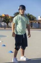 Teenage boy with Down syndrome enjoying outdoor sports activities, wearing safety equipment