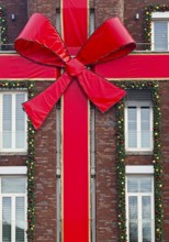 Large red ribbon on a house façade in the run-up to Christmas, Roermond, Limburg province, the