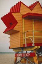 A vibrant, colorful lifeguard stand at Miami Beach, featuring a bold red and yellow color scheme