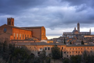 A stunning view of Siena at sunset, featuring the illuminated San Domenico Basilica and the Siena