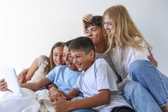 A joyful moment at home with five siblings, an older brother and sister with their younger triplet