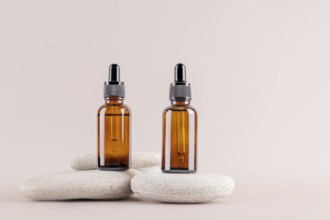 Two amber glass dropper bottles on minimalist stones, set against a neutral background Ideal for