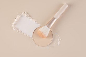 Top view of a makeup setting displaying a compact with loose face powder beside it, scattered