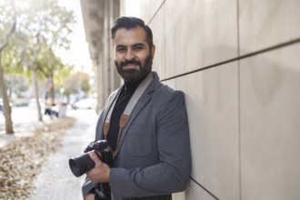 Indian photographer strolling confidently through an urban setting, showcasing a professional