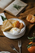 Delicious crepes filled with citrus fruits and yogurt, served on a vintage dish beside a rustic