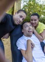 Spanish Cameroonian siblings sharing a joyful moment outdoors. One sibling has cerebral palsy. This