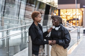 Happy LGBT multiethnic couple enjoying a cheerful moment outdoors in the city during sunset,