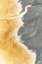 A stunning aerial view of multicolor mud reveals intricate cracks and patterns Earthy tones of gray