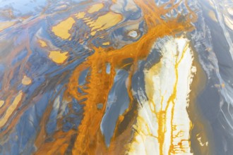An intricate display of vibrant, swirling abstract textures featuring a dynamic blend of orange,