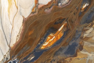 Abstract texture featuring swirling earthy tones intermixed with vibrant orange, cream, and teal