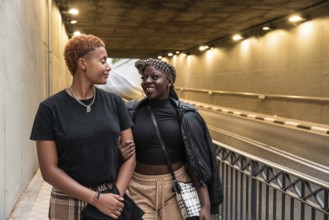 An LGBT multiethnic couple shares a joyful moment while strolling through an illuminated urban