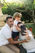 A joyful moment as a gay couple takes a selfie with their son in a sunlit garden. Embracing