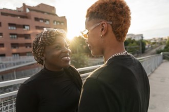 A loving LGBT multiethnic couple shares a tender moment while basking in the warm glow of the