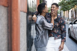 A joyful latin gay couple shares a tender moment on a vibrant street in Madrid. Their happiness and