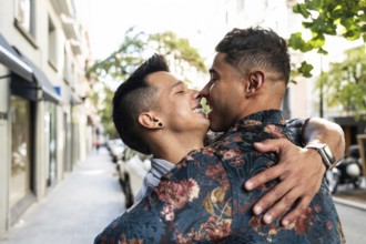 A joyful latin gay couple shares a tender embrace on a vibrant Madrid street. Capturing their love