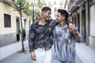A joyful latin gay couple strolls arm in arm through a charming Madrid street, sharing smiles and