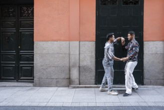 A joyful latin gay couple shares a moment of affection on a lively street in Madrid. Their
