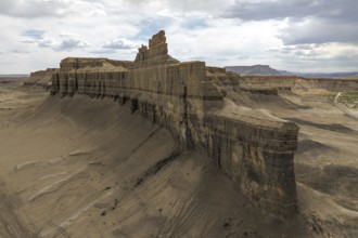A dramatic aerial view of Caineville Mesa, Utah, showcasing towering rock formations and expansive