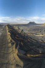 Aerial view of Caineville Mesa in Utah, showcasing rugged terrain and dramatic shadows under a vast