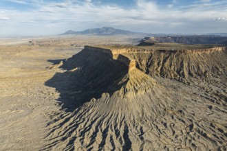 Dramatic aerial view of Caineville Mesa in Utah, USA, showcasing rugged terrain, layered rock
