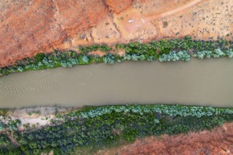 Stunning aerial shot captures the vibrant Rio San Juan slicing through Utah's red landscape,