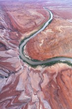 An aerial shot captures the serpentine path of Rio San Juan as it carves through the striking red