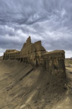 Moody clouds loom over the rugged Caineville Mesa in Utah, USA, highlighting the dramatic landscape