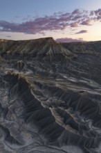 Dramatic view of Caineville Mesa in Utah at sunrise, showcasing unique geological formations and