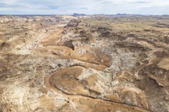 Aerial drone view captures the rugged and barren landscape of Hanksville, Utah, featuring winding