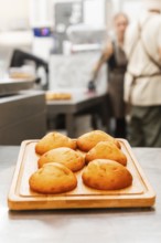 Golden-brown pastries rest on a wooden tray in an Italian bakery, exuding warmth and inviting