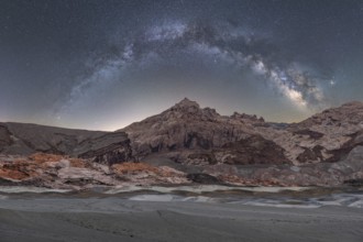 A breathtaking panoramic view of the Milky Way arching over the rugged landscapes of the Utah