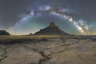 Stunning nighttime scene showcasing the Milky Way arcing over the dramatically textured landscape