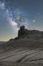 Unrecognizable person silhouette stands on a rugged Utah desert terrain under a vivid Milky Way.