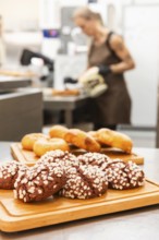 A variety of freshly baked Italian pastries are displayed on wooden trays in a bustling bakery In