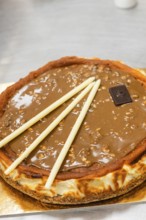 A mouthwatering Italian cake topped with a glossy chocolate glaze and garnished with elegant white