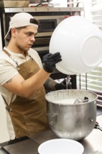 A focused baker in an apron and cap prepares dough in a busy Italian bakery kitchen The setting