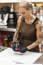 A skilled artisan in a bakery, wearing an apron and gloves, meticulously works on a piece of pastry