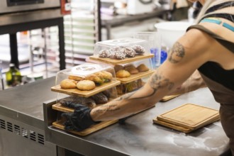 A baker prepares pastry boxes full of Italian delicacies Behind the counter, fresh pastries are
