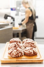 A display of freshly baked Italian pastries topped with sugar crystals on a wooden board A baker