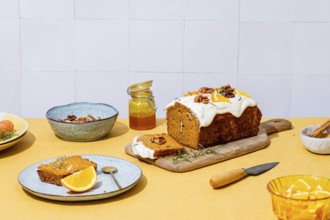 A mouthwatering carrot cake loaf topped with creamy cheese frosting, walnuts, and rosemary Vibrant