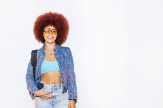 African descendant woman with a vibrant afro hair, smiling while wearing orange sunglasses and a