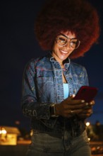 African descendent woman with a vibrant afro hairstyle, wearing glasses, joyfully engaging with her