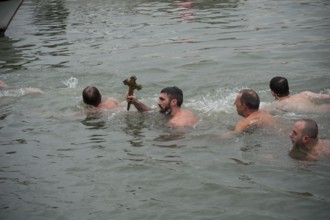 Istanbul, Turkey, January 6th 2017 A man holds a wooden cross after retrieving it from the Golden