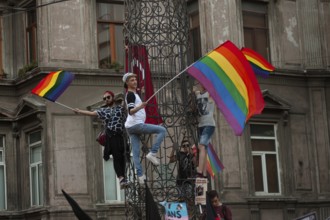 Istanbul, Turkey. August 21st, 2016 Rainbow flag waiving protestors climb a statue near Istiklal