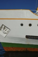 The bright colours of a ship's hull against a dark blue sky