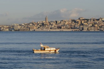 Istanbul, Turkey. August 19th 2014 A small fishing boat on the Bosporus straight with the Galata