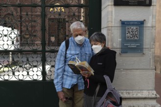Istanbul, Turkey. October 5th 2021 Foreign tourists wearing protective masks reading a guide book