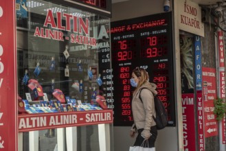Istanbul, Turkey. November 28th 2020 A woman wearing a protective facemask enters and currency and
