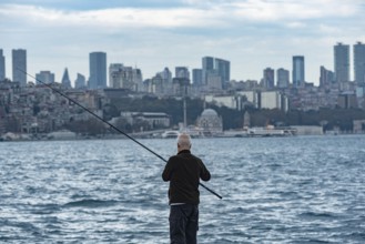 Istanbul, Turkey. November 22nd 2023 An old Turkish man fishing the Bosporus with a view of the