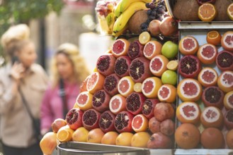 Brightly colored fresh and healthy fruit such as pomegranates and oranges for sale at a juice stall